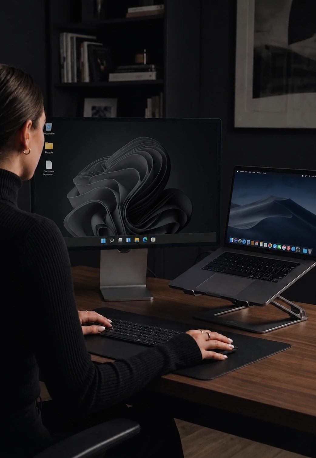 One keyboard and mouse controlling a Windows monitor and a MacBook side by side on a desk